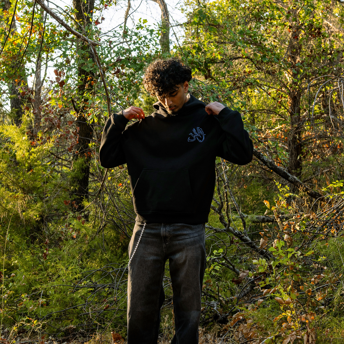Wahid Black Forest Hoodie, Black Forest colorway — model wearing the hoodie outdoors, front graphic visible