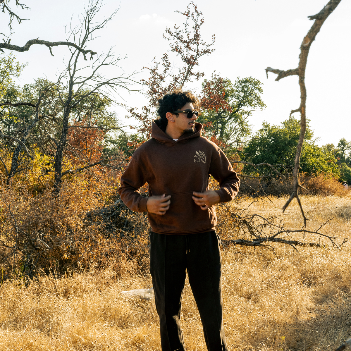 Wahid Mocha Hoodie, Mocha colorway — model wearing the hoodie outdoors, front graphic visible
