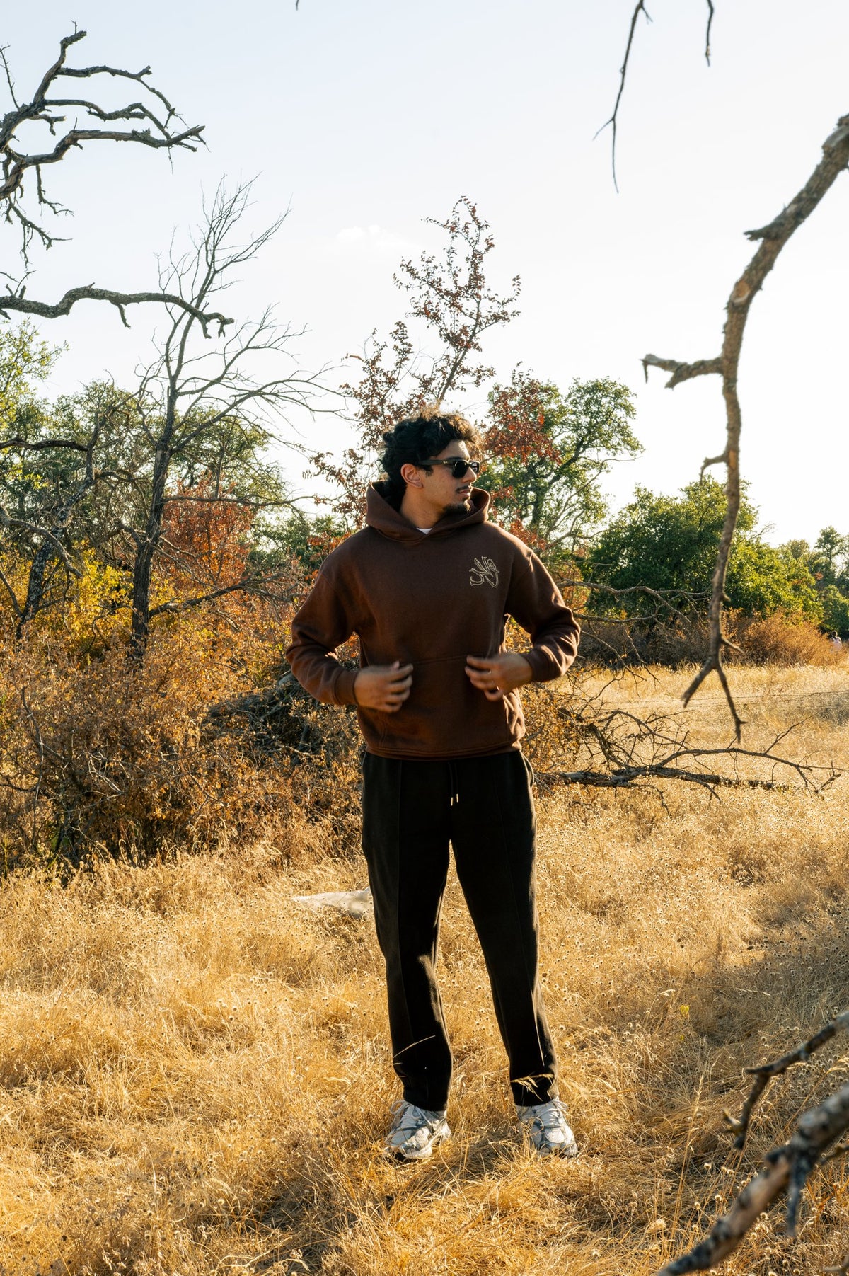 Model wearing the mocha Wahid hoodie outdoors